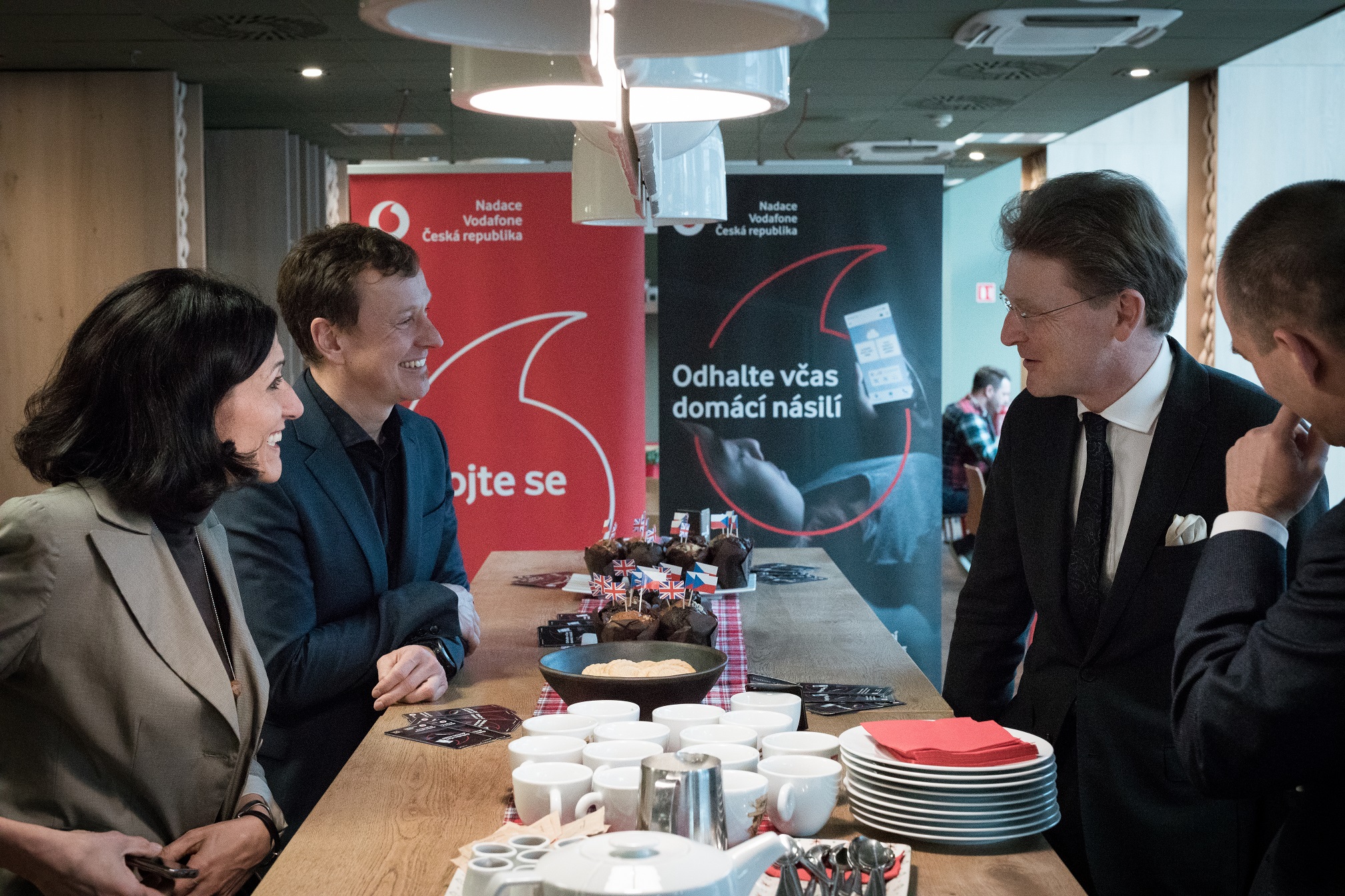 Britský velvyslanec Nick Archer v centrále Vodafonu mluví s generálním ředitelem Vodafonu Petrem Dvořákem a Adrianou Dergam z Nadace Vodafone